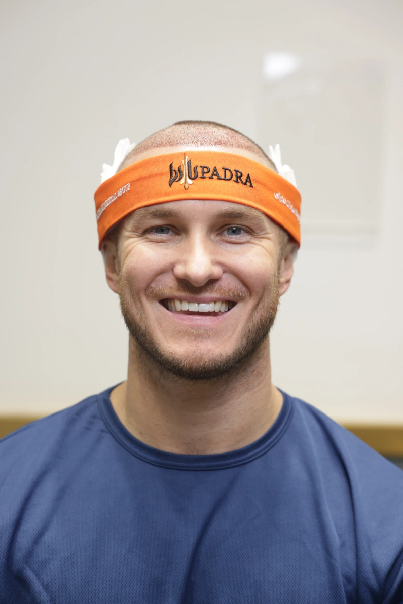 Smiling male patient immediately after a hair transplant at Padra Clinic