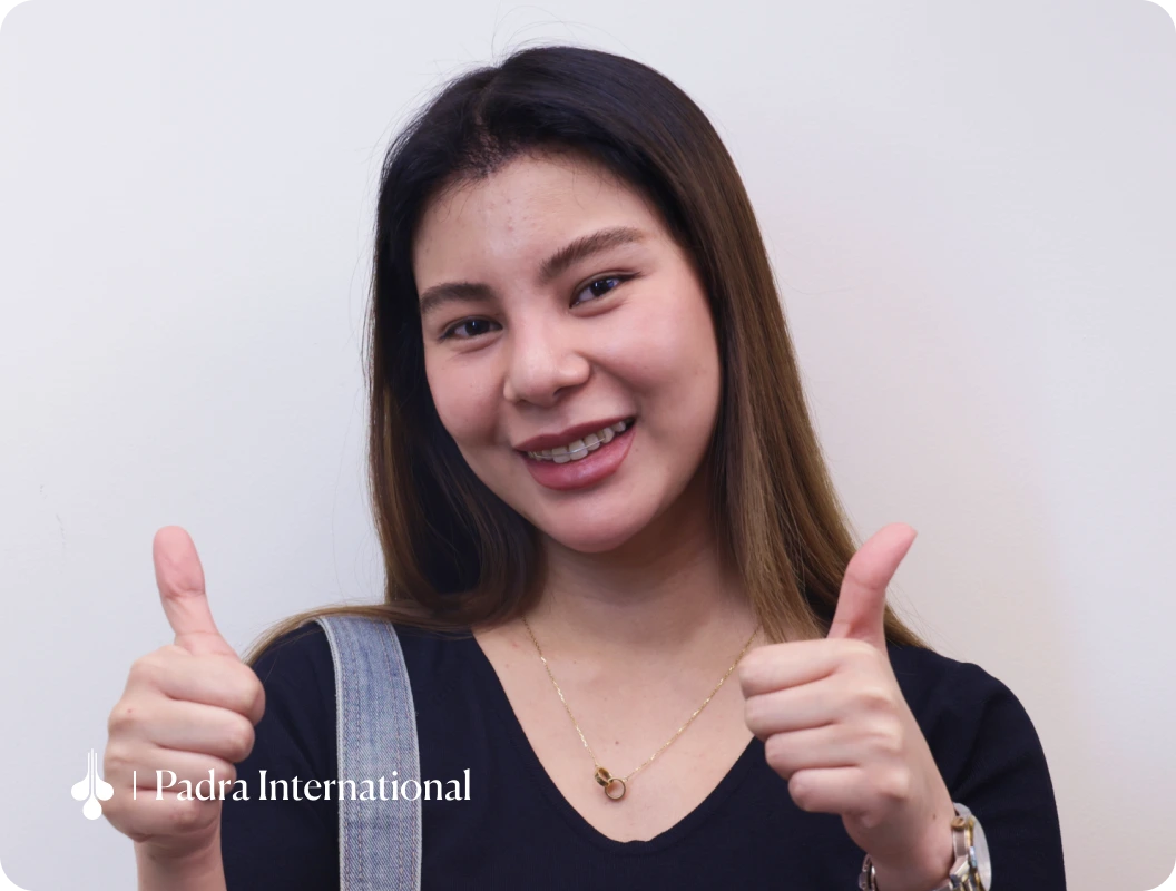 Happy female patient giving two thumbs up after her experience with Padra International