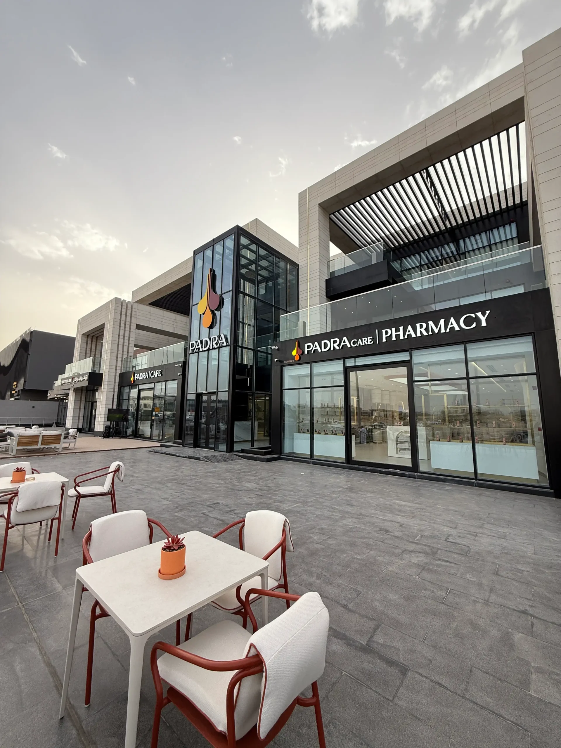 Exterior view of Padra Clinic, Padra Café and Padra Care Pharmacy with outdoor seating